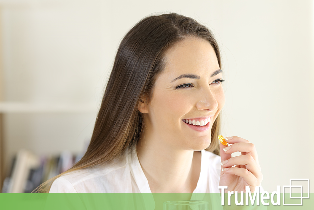 young woman healthy taking her pills from Edmonton Naturopaths